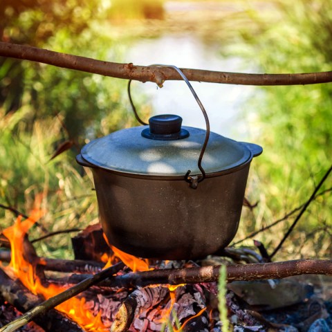 Photo of cast iron pot hanging over a campfire
